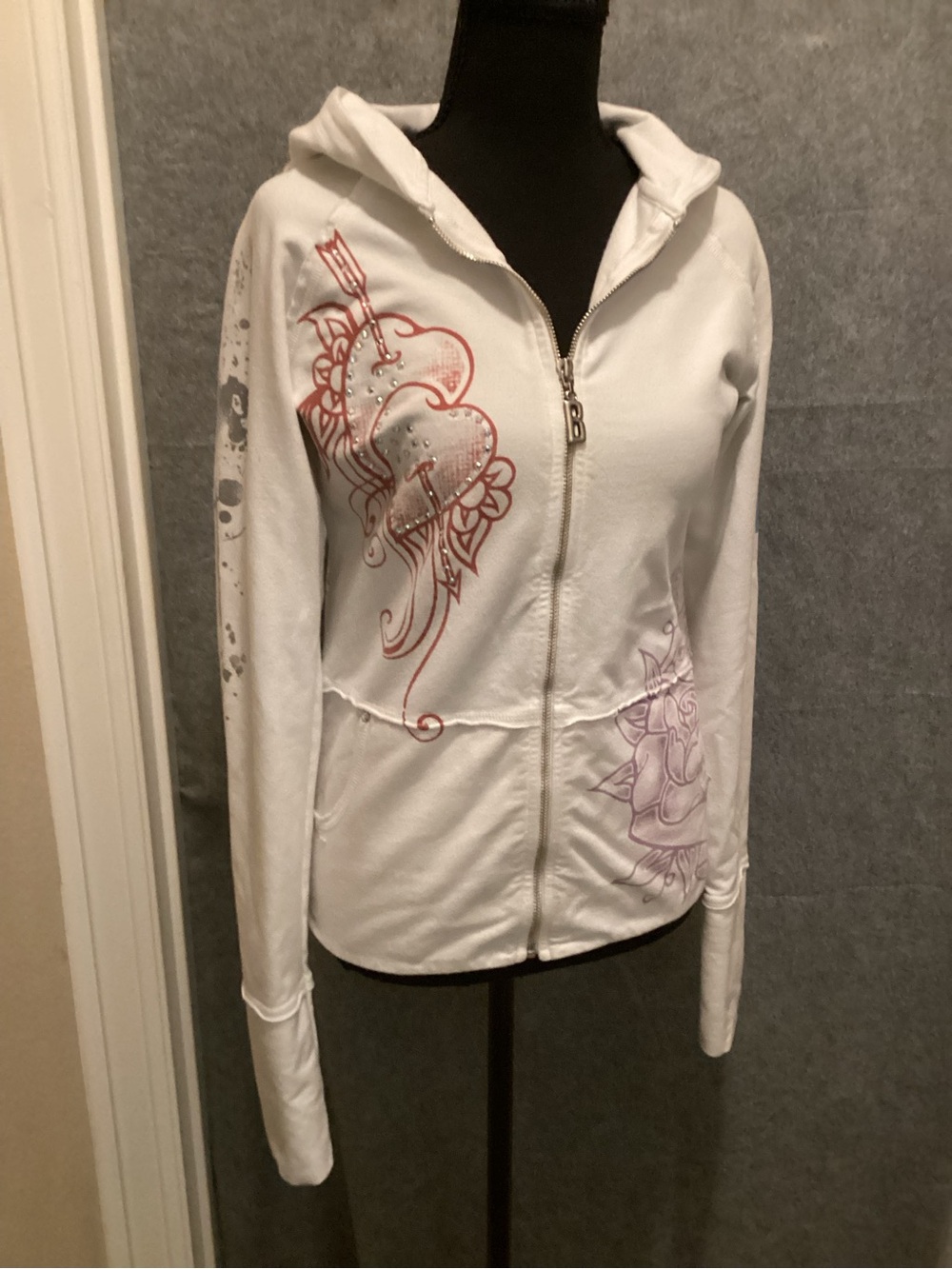 C46. Bejeweled, by Susan Fixel. White Hooded Zip-Up Jacket with Graphics.